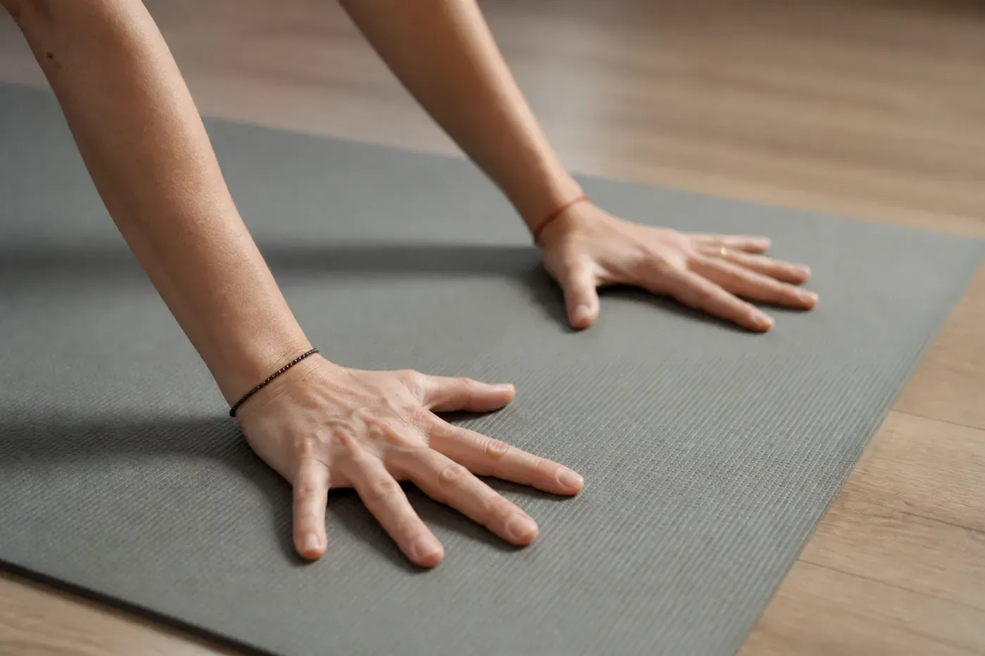 Mani appoggiate sul tappetino durante una lezione di yoga allo studio Fiorire di Pescara.
